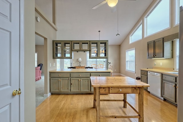 kitchen with ceiling fan, dishwasher, light hardwood / wood-style flooring, high vaulted ceiling, and decorative light fixtures