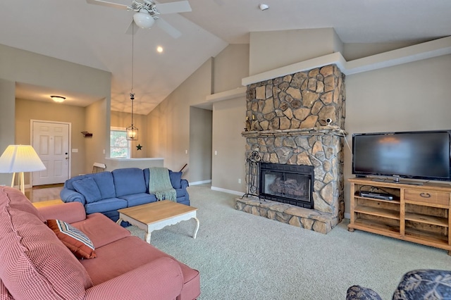 living room with carpet floors, high vaulted ceiling, a stone fireplace, and ceiling fan