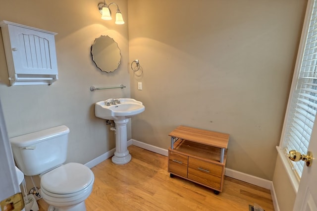 bathroom featuring wood-type flooring and toilet