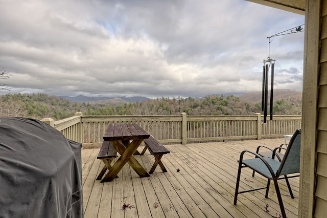 wooden terrace featuring a mountain view and a grill