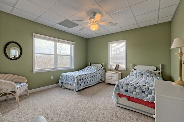 carpeted bedroom featuring a paneled ceiling and ceiling fan