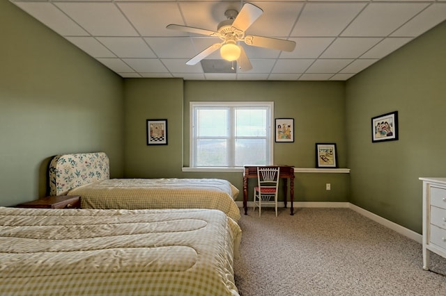 carpeted bedroom featuring ceiling fan and a drop ceiling