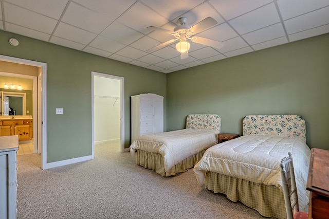 bedroom featuring carpet, a walk in closet, a paneled ceiling, ceiling fan, and a closet