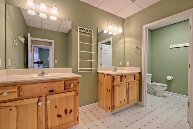 bathroom with vanity, a drop ceiling, and toilet