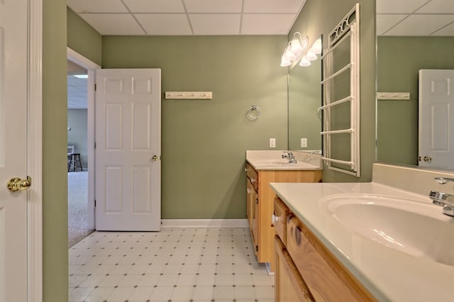 bathroom featuring vanity and a drop ceiling