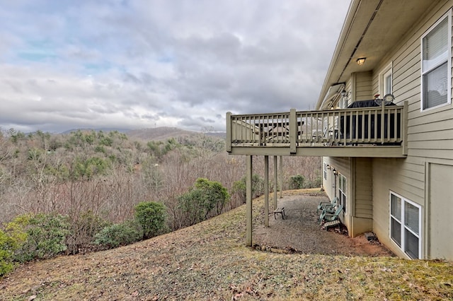 view of yard featuring a deck with mountain view