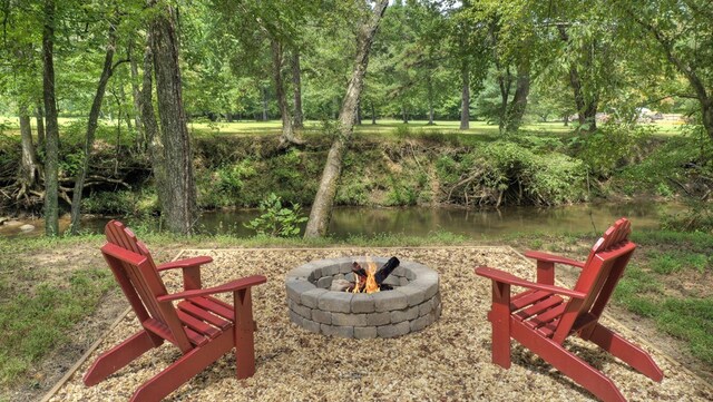 exterior space with a fire pit and a water view