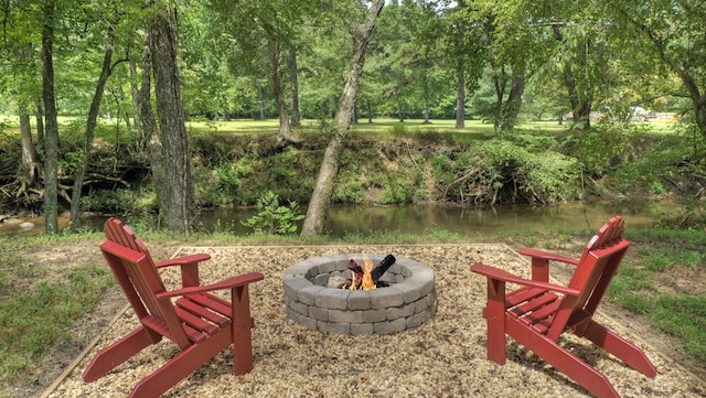 view of yard with a fire pit and a water view