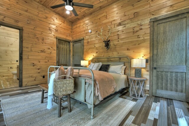 bedroom with wooden ceiling, high vaulted ceiling, hardwood / wood-style flooring, ceiling fan, and wooden walls