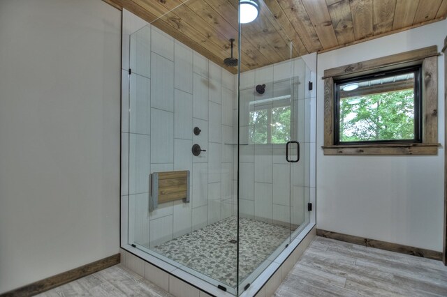 bathroom featuring a shower with shower door, wood-type flooring, and wooden ceiling