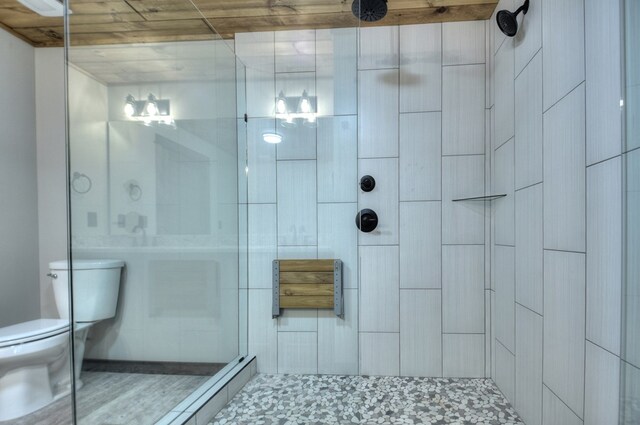 bathroom with wooden ceiling, toilet, and a shower with shower door