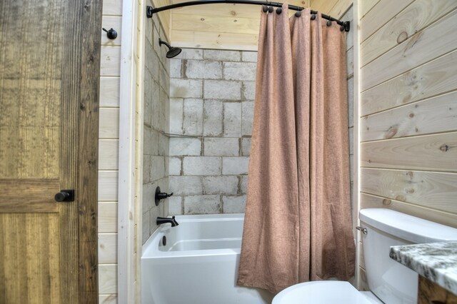 bathroom with toilet, shower / tub combo, and wooden walls