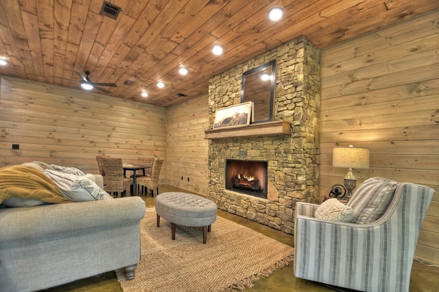 living room with a fireplace, wooden walls, ceiling fan, and wooden ceiling