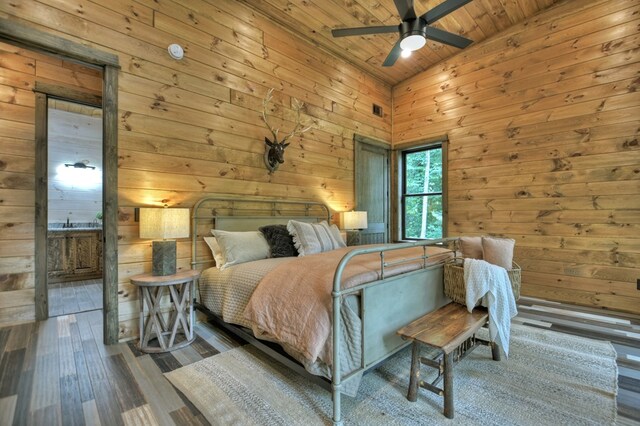 bedroom with ceiling fan, wood walls, wooden ceiling, and hardwood / wood-style flooring