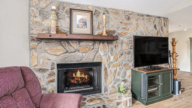 interior space featuring a textured ceiling, a fireplace, and wood finished floors