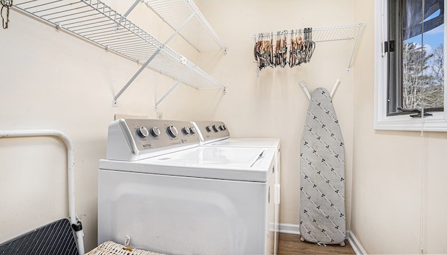 laundry area featuring laundry area, baseboards, washer and clothes dryer, and wood finished floors