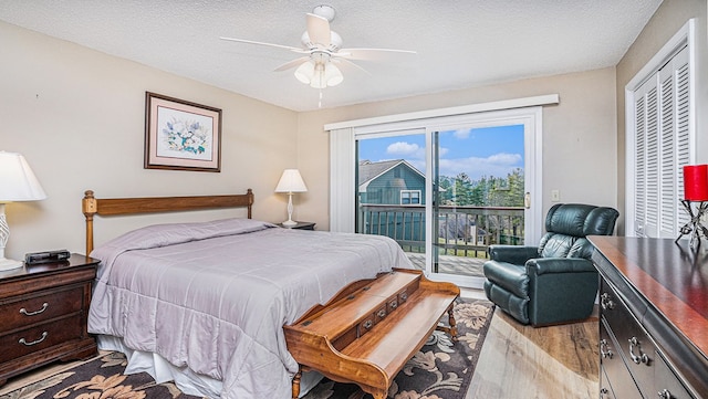 bedroom with a ceiling fan, access to outside, a textured ceiling, and wood finished floors