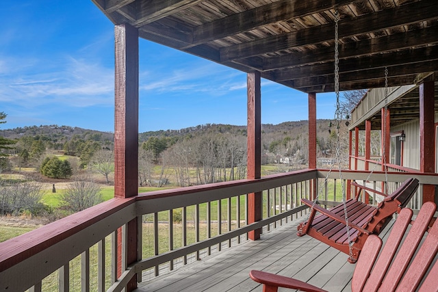 wooden deck featuring a forest view and a mountain view