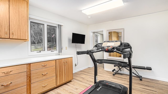 workout room with light wood finished floors and baseboards