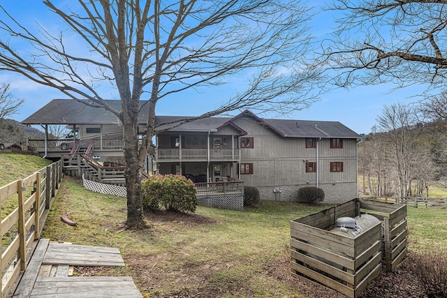 back of property with a lawn, crawl space, stairs, fence, and a deck