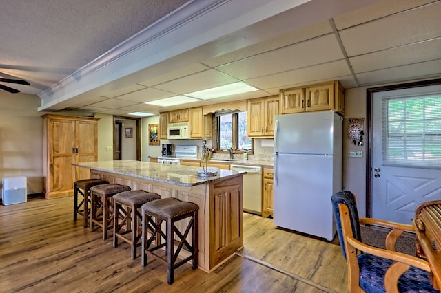 623 Overlook Way, Sky Valley, GA 30537 - kitchen with white appliances, light stone counters, light wood-type flooring, a breakfast bar area, and a kitchen island
