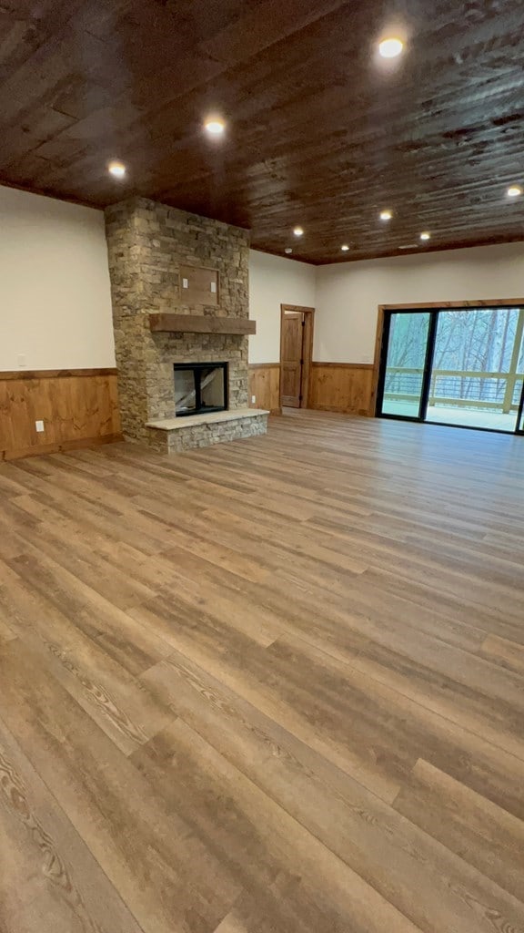 unfurnished living room featuring recessed lighting, wood finished floors, and a wainscoted wall