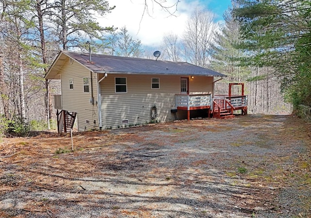 rear view of property featuring a wooden deck