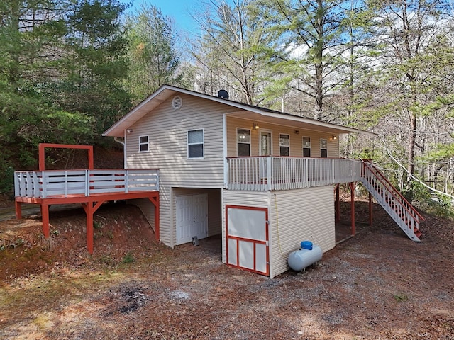 rear view of property with stairway and a deck