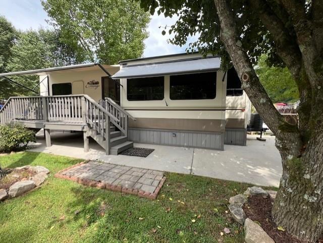 back of property with a lawn and a patio