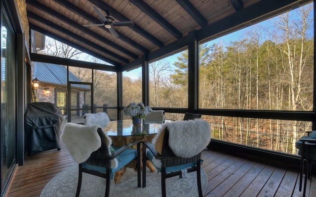 sunroom with ceiling fan, outdoor dining area, and beamed ceiling