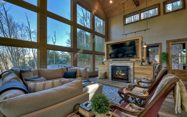 living room featuring a glass covered fireplace, wood finished floors, wood ceiling, and high vaulted ceiling