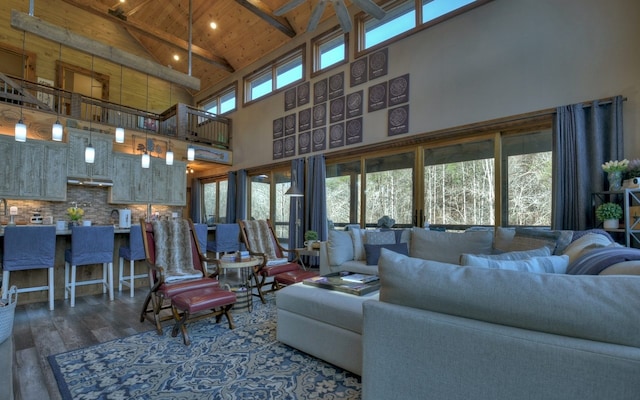 living area featuring high vaulted ceiling, wooden ceiling, beam ceiling, and wood finished floors