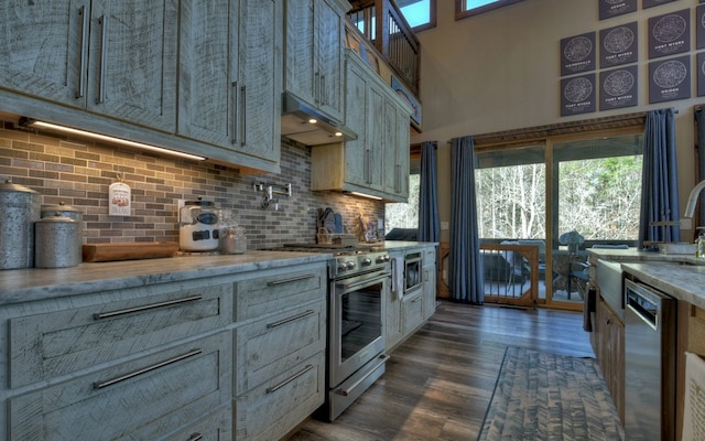 kitchen with under cabinet range hood, a wealth of natural light, appliances with stainless steel finishes, and tasteful backsplash