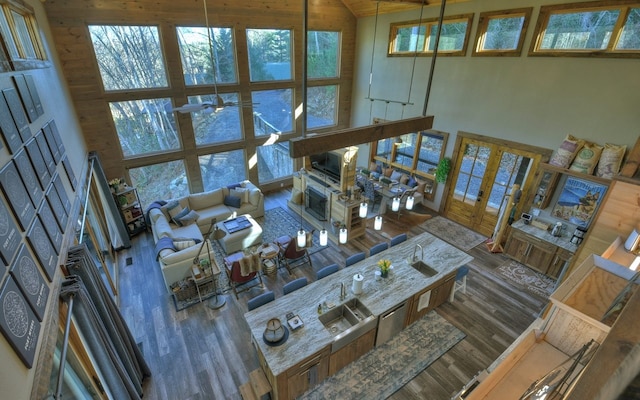 living room with wood finished floors, a towering ceiling, and a ceiling fan