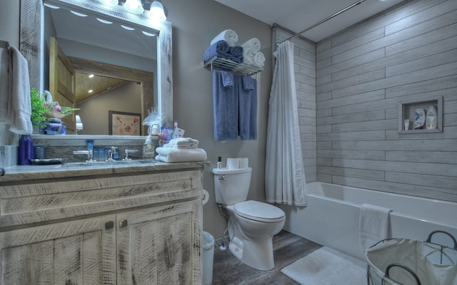 bathroom featuring shower / bath combo with shower curtain, wood finished floors, vanity, and toilet