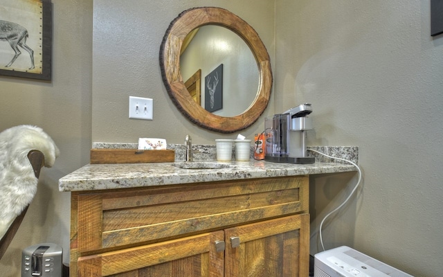 bathroom featuring a textured wall and vanity