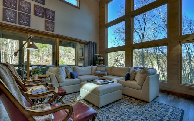 living area featuring a towering ceiling and hardwood / wood-style floors