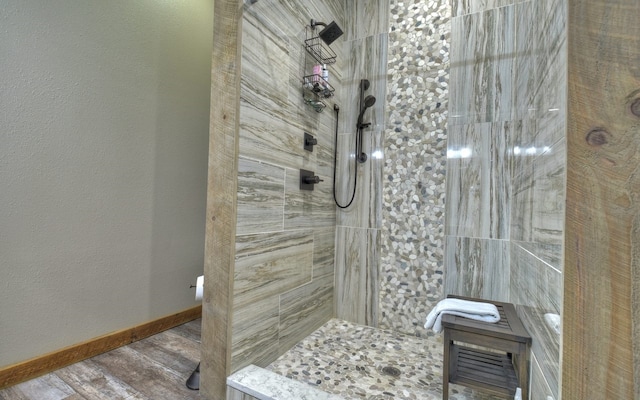 full bath with wood finished floors, baseboards, and a walk in shower