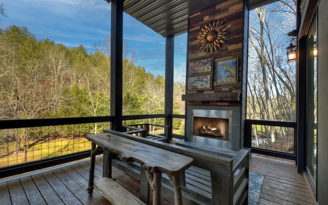 sunroom with a warm lit fireplace