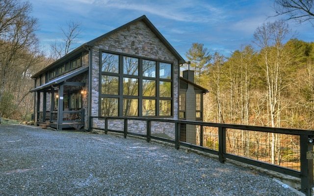 rear view of property with stone siding