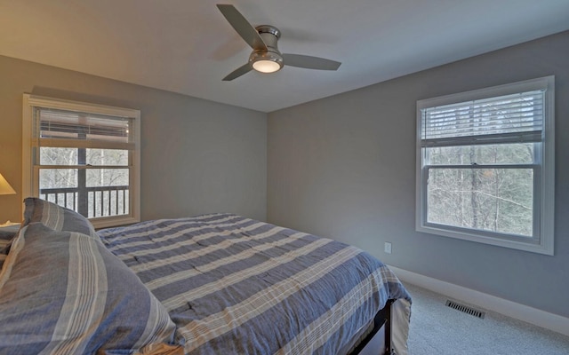 bedroom featuring carpet floors, multiple windows, ceiling fan, and baseboards