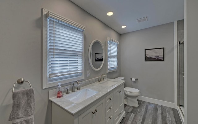 bathroom featuring wood finished floors, a sink, visible vents, and baseboards