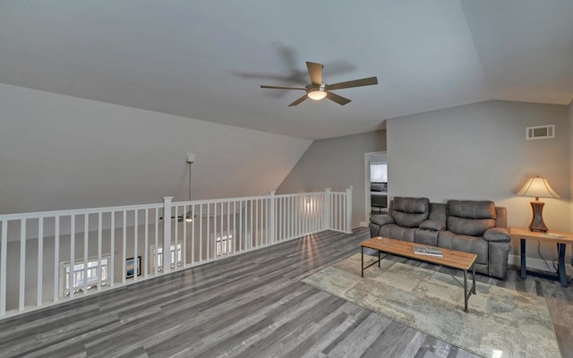 living room featuring ceiling fan, visible vents, vaulted ceiling, and wood finished floors