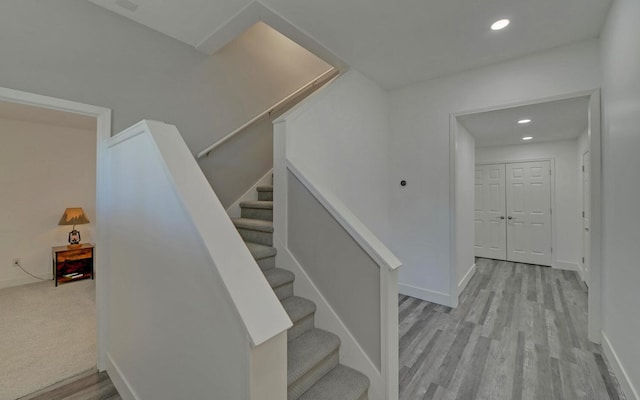 stairs featuring baseboards, wood finished floors, and recessed lighting