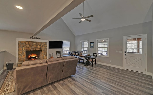 living area with high vaulted ceiling, wood finished floors, a wealth of natural light, and baseboards