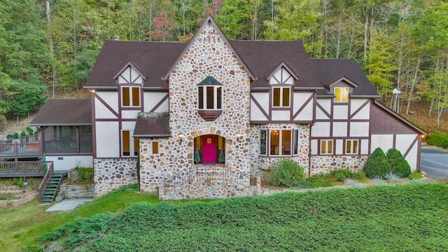 tudor house with stone siding, stucco siding, and a forest view