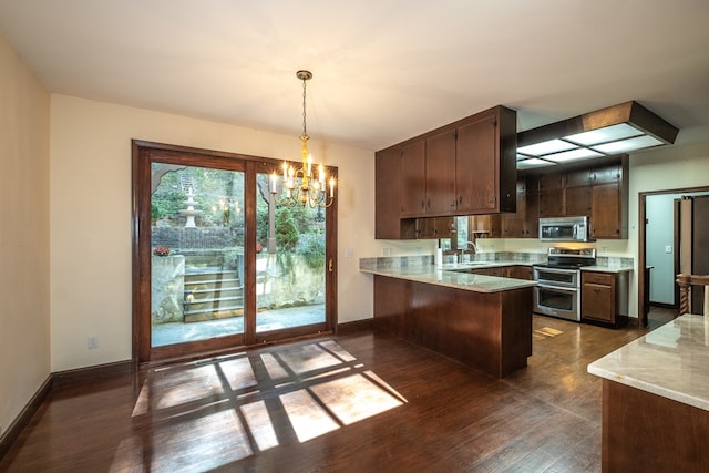 kitchen featuring appliances with stainless steel finishes, a chandelier, a peninsula, and dark wood-style floors