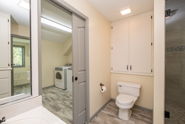 full bath with independent washer and dryer, toilet, and baseboards