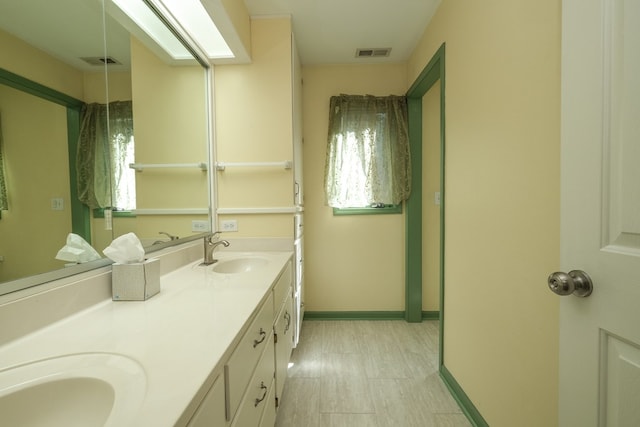 bathroom featuring double vanity and baseboards