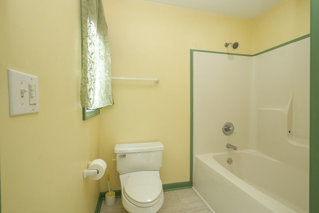 bathroom with toilet, baseboards, and shower / bath combination